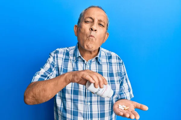 Senior Latinamerikan Man Håller Piller Gör Fisk Ansikte Med Mun — Stockfoto