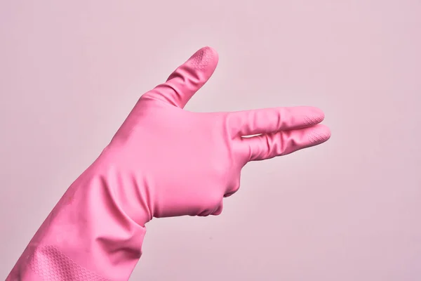 孤立したピンクの背景の上に手袋を掃除している白人青年の手指で銃の武器をジェスチャー 撮影シンボルを目指して — ストック写真
