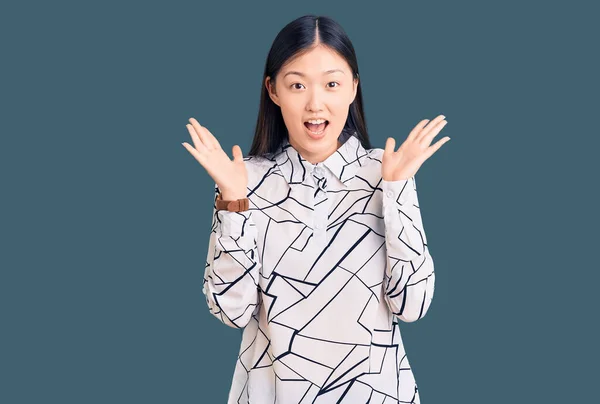 Jonge Mooie Chinese Vrouw Draagt Casual Shirt Vieren Gek Verbaasd — Stockfoto