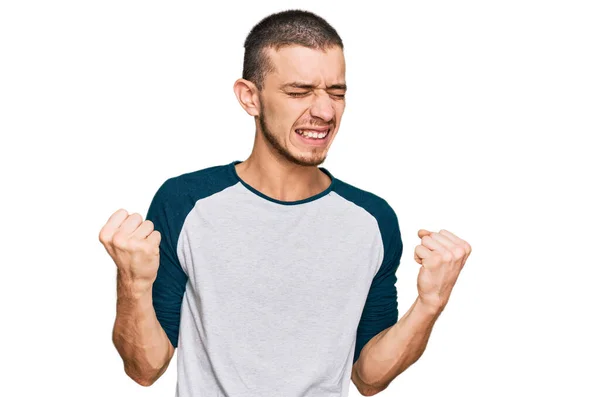 カジュアル服を着てヒスパニック系の若い男は非常に幸せと腕を上げて勝者のジェスチャーを行う興奮 笑顔と成功のために叫んで お祝いのコンセプト — ストック写真
