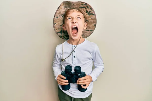 Pequeño Niño Caucásico Con Sombrero Explorador Sosteniendo Prismáticos Enojado Loco — Foto de Stock