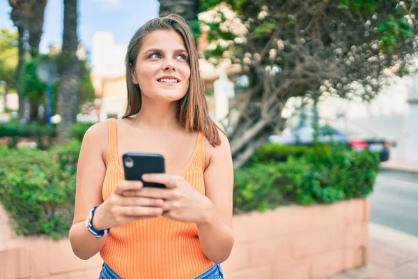 若い中東の女の子笑顔幸せな使用してスマートフォンで市内 — ストック写真