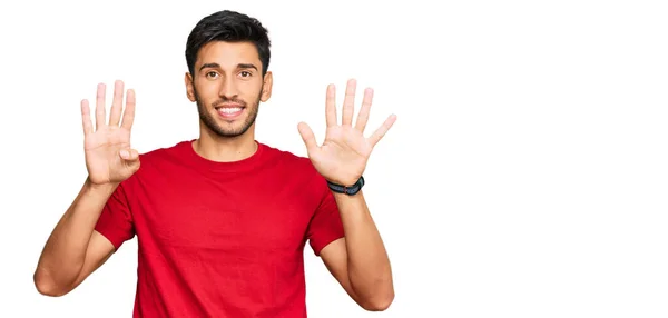 年轻英俊的男子穿着随意的红色T恤 手指着9号 面带微笑 自信而快乐 — 图库照片