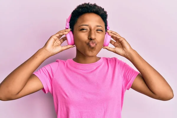 Joven Afroamericana Chica Escuchando Música Usando Auriculares Mirando Cámara Soplando — Foto de Stock