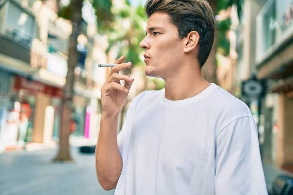Молодой Кавказский Мужчина Серьезным Выражением Лица Курит Сигарету Городе — стоковое фото