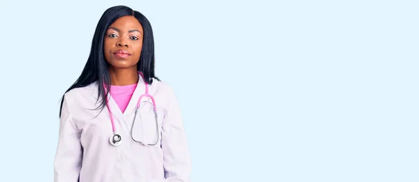 医師の聴診器を身に着けている若いアフリカ系アメリカ人女性は 顔に深刻な表情でリラックスしました カメラを見ているだけで — ストック写真