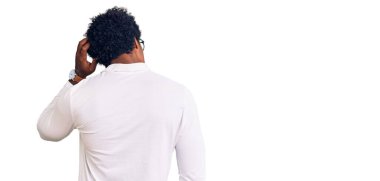 Afro saçlı, sıradan giyinmiş ve gözlüklü yakışıklı Afro-Amerikan adam. Elleri başının üstünde şüpheyi düşünüyor. 