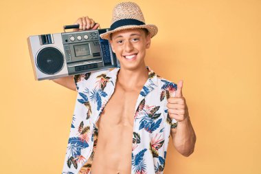 Yaz stili müzik çalan, gülümseyen, mutlu ve olumlu müzik dinleyen, harika bir işaret veren İspanyol çocuk. 