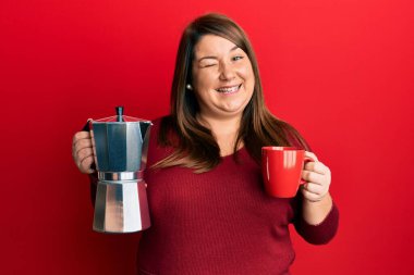 Güzel esmer, iri yarı, İtalyan kahvesi içen, kameraya seksi bir ifadeyle bakan, neşeli ve mutlu yüzlü bir kadın.. 