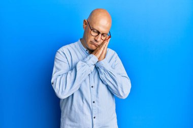 Orta yaşlı kel bir adam günlük kıyafetler ve gözlükler takmış uyur, yorgun düşler kurar ve elleriyle poz verir, gözleri kapalı gülümserdi.. 