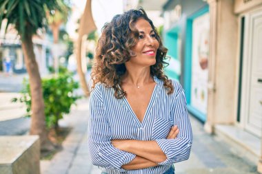 Orta yaşlı İspanyol kadın gülümseyerek şehirde mutlu mesut yürüyor..