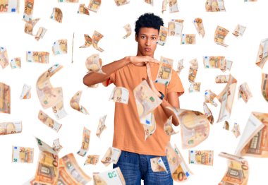 Genç Afro-Amerikan adam günlük kıyafetler giyiyor. El kol hareketleri yapıyor, hayal kırıklığına uğramış ve ciddi bir yüz ifadesi takınıyor.