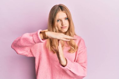 Güzel, genç, beyaz bir kız, günlük kıyafetler giyiyor, el kol hareketleri yapıyor, hayal kırıklığına uğramış ve ciddi bir yüz ifadesi takınıyor. 