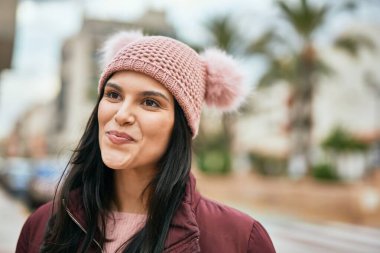 Genç İspanyol kız gülümseyerek şehirde mutlu mesut dikiliyor..