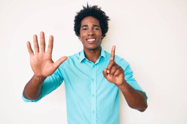 Yakışıklı Afro saçlı, sıradan giyinmiş, 6 numarayı gösterip gülümseyen, kendinden emin ve mutlu Afro-Amerikan adam.. 