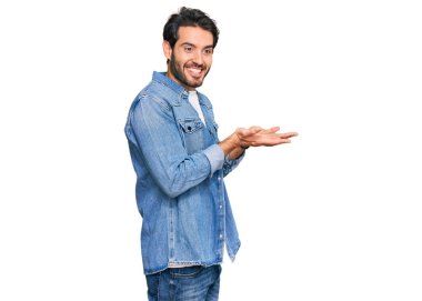 Gündelik kıyafetler giyen genç İspanyol adam avuçlarını açıp fotokopi alanını gösteriyor. Reklam sunuyor, gülümsüyor, mutlu ve heyecanlı. 