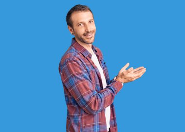 Sıradan kıyafetler giyen genç yakışıklı adam avuçlarını açıp fotokopi alanını gösteriyor. Reklam sunuyor, gülümsüyor, mutlu bir şekilde gülümsüyor. 