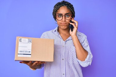 Elinde saç örgüsü olan genç Afro-Amerikalı kadın şüpheli ve sinirli yardımcıları arıyor, sorun yüzünden surat asıyor. negatif kişi. 