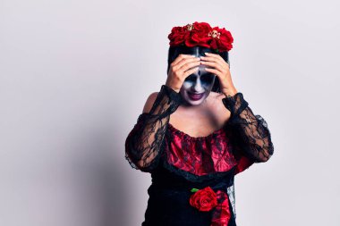 Meksika usulü makyaj yapan genç bir kadın. Ağrı ve migren yüzünden baş ağrısı ve stresten muzdarip. Eller başının üstünde.. 