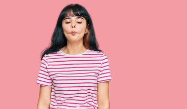 Gündelik kıyafetler giyen genç İspanyol kız dudaklarıyla balık suratı yapıyor, çılgınca ve komik bir jest. Komik ifade. 