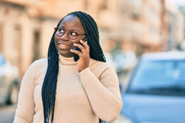 Young african american woman talking on the smartphone at the city.