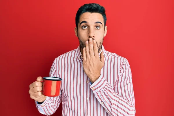 Jeune Homme Hispanique Tenant Café Couvrant Bouche Avec Main Choqué — Photo