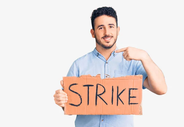 Young Hispanic Man Holding Strike Banner Cardboard Pointing Finger One — Stock Photo, Image