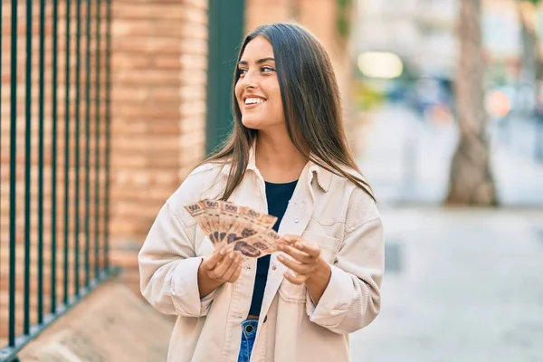 若いですヒスパニック系の女の子笑顔幸せな保持メキシコ500ペソ紙幣で街 — ストック写真