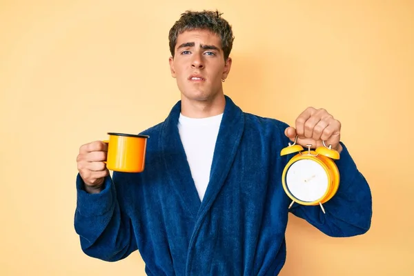 Egy Fiatal Jóképű Férfi Fürdőköpenyben Kezében Egy Csésze Kávéval Ébresztőórával — Stock Fotó