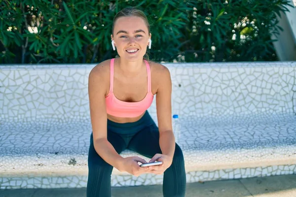 Mladá Blondýna Sportovkyně Dělá Cvičení Pomocí Smartphone Sedí Lavičce Parku — Stock fotografie