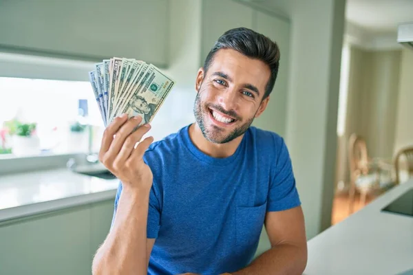 Fiatal Jóképű Férfi Mosolyog Boldog Kezében Amerikai Dollár Bankjegyek Otthon — Stock Fotó