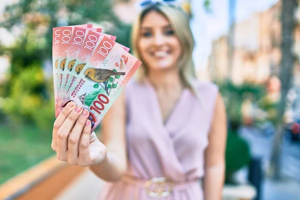Νεαρή Ξανθιά Γυναίκα Χαμογελά Ευτυχισμένη Κρατώντας Χαρτονομίσματα Των 100 Δολαρίων — Φωτογραφία Αρχείου