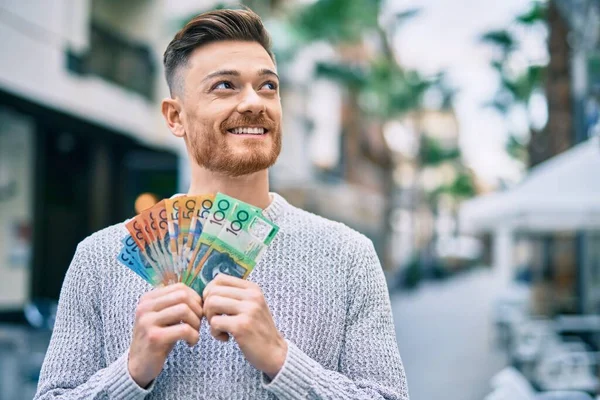 Młody Biały Mężczyzna Uśmiecha Się Szczęśliwy Trzymając Australijskie Dolary Mieście — Zdjęcie stockowe
