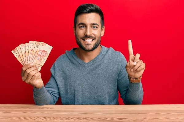 Hombre Hispano Guapo Sosteniendo Pesos Mexicanos Sonriendo Con Una Idea — Foto de Stock