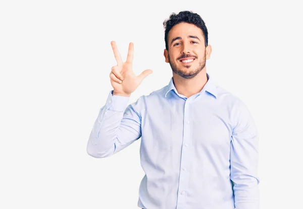 自信と幸せな笑顔ながら 若いヒスパニック系の男は ビジネス服を着て見せ 指の数3で指摘します — ストック写真