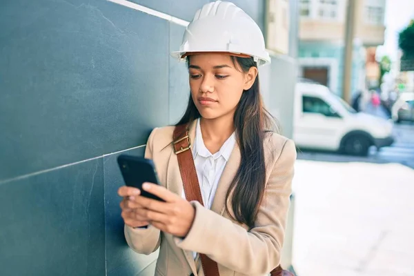 年轻的拉丁建筑师女孩在城市里用智能手机进行严肃的表达 — 图库照片