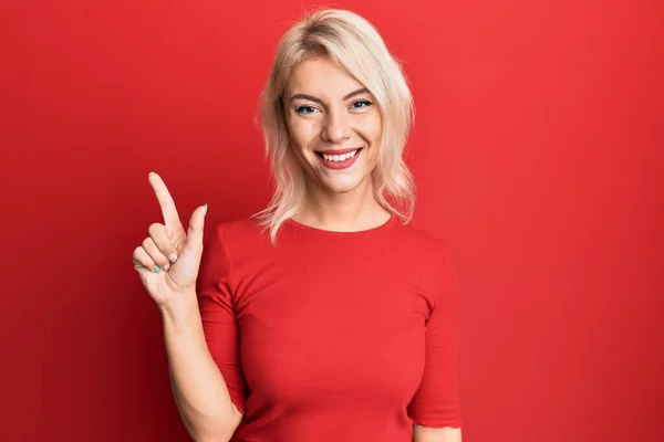 Junges Blondes Mädchen Lässiger Kleidung Zeigt Mit Finger Nummer Eins — Stockfoto