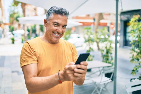 Středního Věku Šedovlasý Muž Úsměvem Šťastný Pomocí Smartphone Chůze Ulici — Stock fotografie