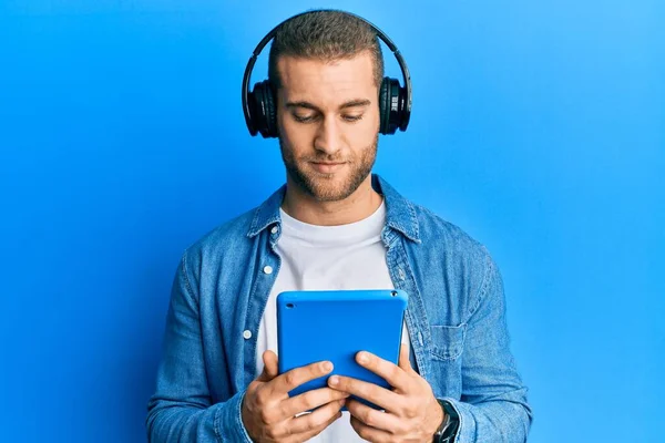 Νεαρός Καυκάσιος Άνδρας Που Χρησιμοποιεί Touchpad Φορώντας Ακουστικά Σκέψης Στάση — Φωτογραφία Αρχείου