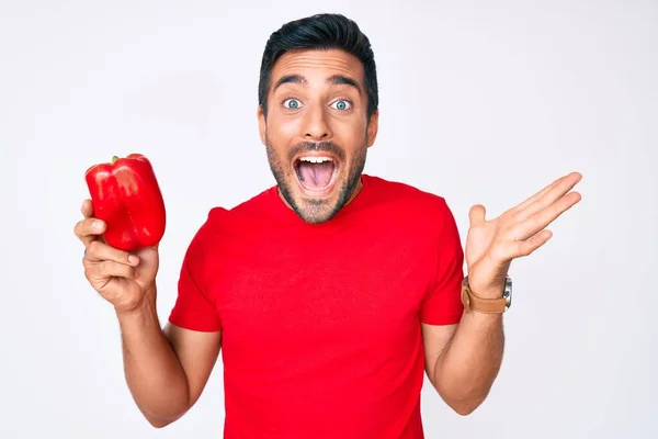 Young Hispanic Man Holding Red Pepper Celebrating Victory Happy Smile — Stock Photo, Image