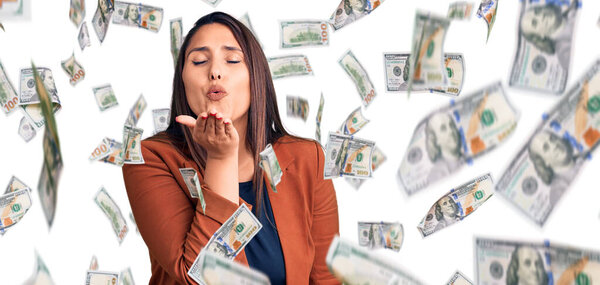 Молодая красивая брюнетка в элегантной одежде, смотрящая на камеру и дуя в камеру, целует рукой в воздух, будучи красивой и сексуальной. выражение любви.