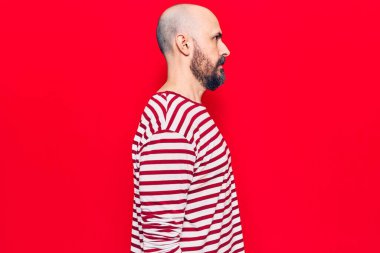 Sıradan kıyafetler giyen genç yakışıklı bir adam, rahat bir görünüm takınıyor kendine güvenen bir gülümsemeyle doğal bir yüz ifadesi takınıyor.. 