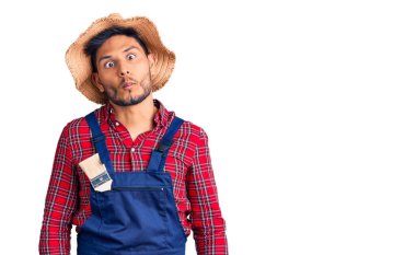 Yakışıklı Latin Amerikalı, tamirci üniforması giyen, dudağıyla balık suratı yapan, çılgın ve komik bir jest. Komik ifade. 