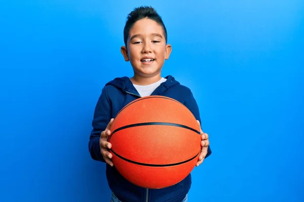 Pequeño Niño Hispano Sosteniendo Bola Baloncesto Guiño Mirando Cámara Con — Foto de Stock