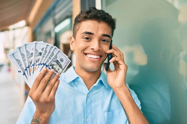 Jonge Latijnse Man Glimlachend Gelukkig Praten Smartphone Met Amerikaanse Dollars — Stockfoto