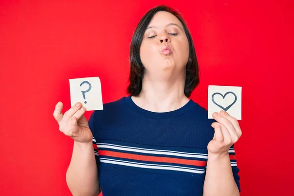 Brunett Kvinna Med Ner Syndrom Håller Hjärta Och Frågetecken Påminnelse — Stockfoto