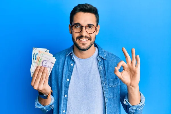 Joven Hispano Sosteniendo Billetes Dólar Singapurenses Haciendo Signo Con Los — Foto de Stock