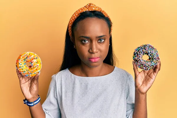 Junge Afrikanerin Hält Leckere Bunte Donuts Entspannt Mit Ernstem Gesichtsausdruck — Stockfoto