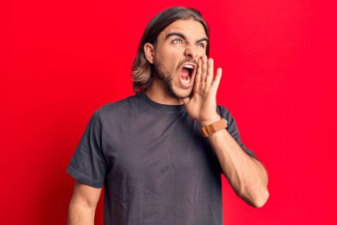 Sıradan kıyafetler giyen genç yakışıklı adam el ele verip bağırarak ve yüksek sesle bağırıyor. iletişim konsepti. 