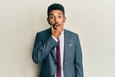 Sakallı, takım elbiseli ve kravatlı yakışıklı bir adam. İnançsızlıktan, şaşkınlıktan ve elleri çenesinde şaşkınlıktan büyülenmiş bir ifade. 